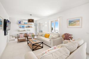 a living room with two couches and a table at Villa Alba by Menorca Vacations in Son Bou