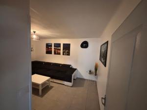 een woonkamer met een zwarte bank en een tafel bij Souki in Geispolsheim