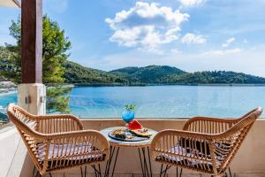 a table on a balcony with a view of a lake at Blue Green Bay in Panormos Skopelos