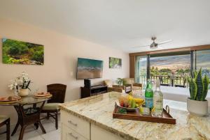 a kitchen with a table with a bowl of fruit on a counter at Lahaina Shores 306 · LS 306 Dream Maui Studio by the Beach Pool in Wainee