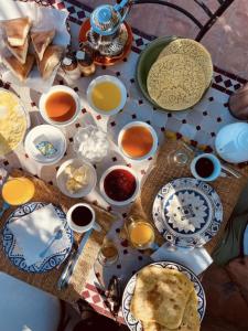 a table with plates and bowls of food on it at Riad Lailouza in Essaouira
