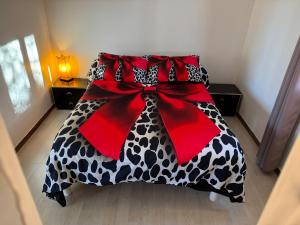 Una cama con una manta blanca y negra con un lazo rojo. en Maison provençale de charme, en Velaux 8 fotos más