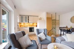 a living room with blue chairs and a kitchen at Ferienwohnung Wald-Ausblick in Willingen