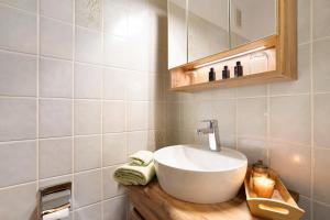 a bathroom with a white sink and a mirror at Ferienwohnung Wald-Ausblick in Willingen +18 photos