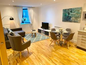 a living room with a couch and a table with chairs at Oxford Castle Apartment in Oxford