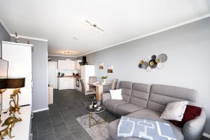 a living room with a couch and a kitchen at Elegantes Meerblick-Apartment in Hansaland