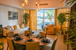 a living room with a table and a couch at Beachside Sunset Residence in Abu Dhabi