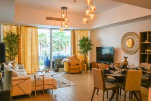 a living room with a table and a dining room at Beachside Sunset Residence in Abu Dhabi