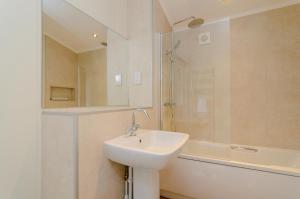 un bagno bianco con lavandino e doccia di Landal Rockingham Forest a Wansford