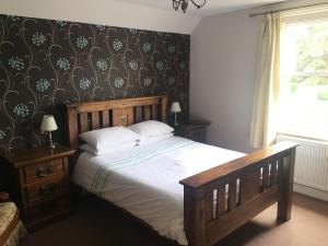 a bedroom with a large bed with a wooden headboard at The Half Moon in Petersfield
