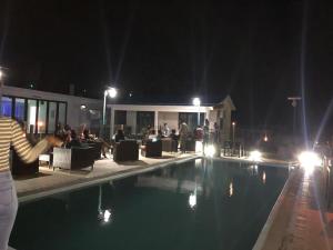 een persoon die 's nachts naast een zwembad staat bij Villa Koki Bonheur Rodrigues in Saint Francois