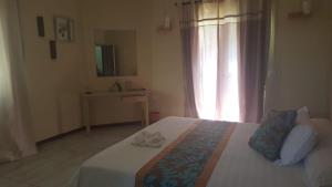 een slaapkamer met een bed, een wastafel en een spiegel bij Villa Koki Bonheur Rodrigues in Saint Francois