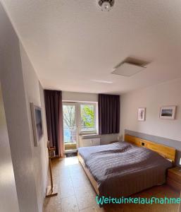 a bedroom with a bed and a window at Seewind 6 in Cuxhaven