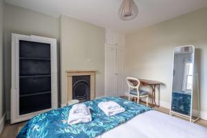 Un dormitorio con una cama con toallas. en Flat 143C Iffley Road by CheckInCheckOut, en Oxford