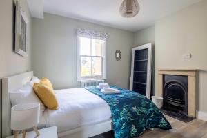 1 dormitorio con 1 cama grande y chimenea en Flat 143C Iffley Road by CheckInCheckOut, en Oxford