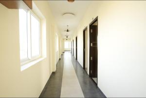 an empty corridor of a building with white walls and windows at Keerthana Marriage hall and Rooms in Coimbatore +2 photos
