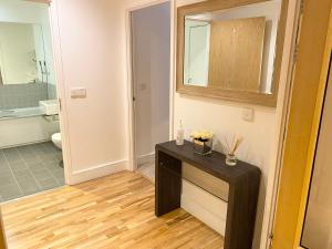 a bathroom with a black table with flowers on it at Oxford Castle Apartment in Oxford +24 photos