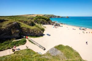 a beach with people on the sand and the ocean at Fresh 4 Bed Coastal Home nr Padstow in Padstow +27 photos