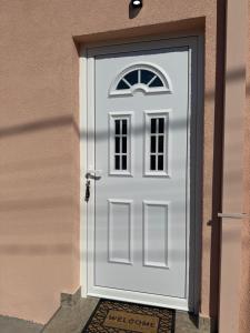 a white door with a window on a building at Apartmani Zabjelo in Podgorica