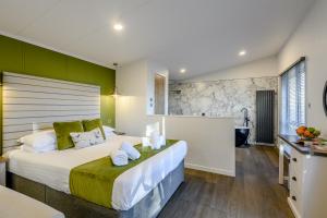 a bedroom with a large bed and a bathroom at Landal Kenwick Woods in Louth