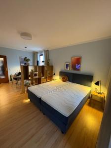 Un dormitorio con una cama grande en una habitación. en Bahnhof Suites I 3 Zimmer I Komfort mit Aussicht und 3 Balkonen, en Bad Bevensen
