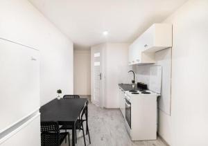 a kitchen and dining room with a table and chairs at Dream Aparts - pokoje blisko dworca Łódź Fabryczna in Łódź