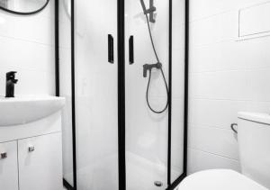 a bathroom with a shower and a toilet and a sink at Dream Aparts - pokoje blisko dworca Łódź Fabryczna in Łódź +9 photos