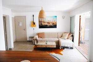 a living room with a couch and a table at Pinarello - Les hameaux 1 in Sainte-Lucie de Porto-Vecchio