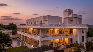 een groot wit gebouw met een zonsondergang op de achtergrond bij Victoria Mansion - A Signature Collection by HST Hotels, Pure Vegetarian in Udaipur