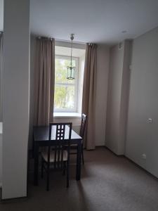 a dining room with a table and chairs and a window at Šiluvos Svaja in Šiluva +13 photos