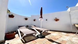 a patio with two chairs and a table and a umbrella at Welooveyou Honey in Costa Calma