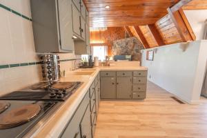 a kitchen with wooden ceilings and a stove top oven at Sequoia Vintage A-frame River Retreat in Three Rivers