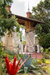 a garden with a white gate and a house at Park Hotel Villa Ariston in Lido di Camaiore