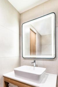 a bathroom with a white sink and a mirror at Hotel Lenexa by Bestinn Leisure in Bengaluru +14 photos