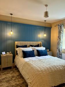 Un dormitorio con una cama grande con paredes azules. en LAKE VIEW Luxury Apartment, en Dunfanaghy
