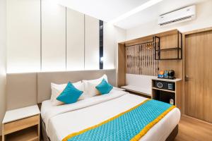 a bedroom with a large bed with blue pillows at Hotel Lenexa by Bestinn Leisure in Bengaluru