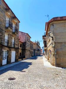 a cobblestone street in an old town with buildings at Hotel Rural O Salazón in Cambados