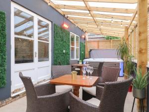 a patio with a table and chairs and a kitchen at Hambleton House in Derby