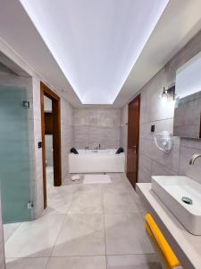 un baño con bañera y lavabo en Anemos Suites Mani, 