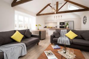 a living room with two couches and a kitchen at The Stables at West Lyham in Chatton