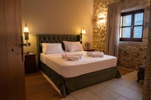 Un dormitorio con una cama grande con sábanas blancas. en Anemos Suites Mani, 