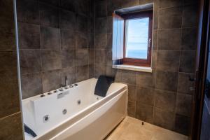Un baño con bañera y ventana. en Anemos Suites Mani,  38 fotos más