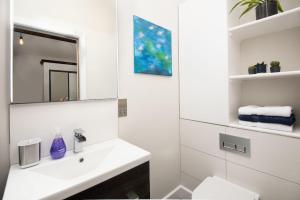 a white bathroom with a sink and a mirror at The Stables at West Lyham in Chatton +17 photos