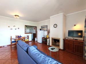 een woonkamer met een blauwe bank en een tv bij 8 1 Figueirinhas - Casas & Papéis in Armação de Pêra