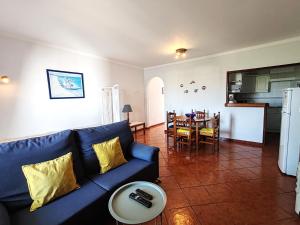 een woonkamer met een blauwe bank en een tafel bij 8 1 Figueirinhas - Casas & Papéis in Armação de Pêra