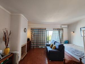 een woonkamer met een bank en een bed bij 8 1 Figueirinhas - Casas & Papéis in Armação de Pêra +29 foto's