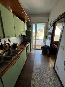 a kitchen with green cabinets and a sink at 3 minutes from train in Venice +11 photos