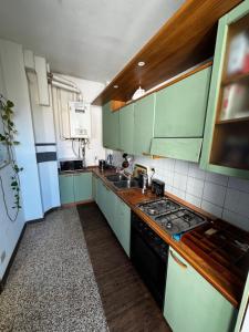 a kitchen with green cabinets and a stove top oven at Cosy Dani stay, easy access to Venice in Mestre