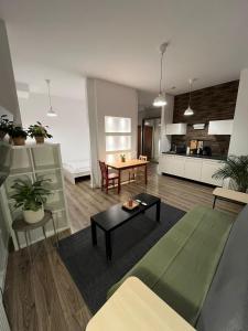 a living room with a couch and a table at Windows to the City Stylish Apartment in Poznań