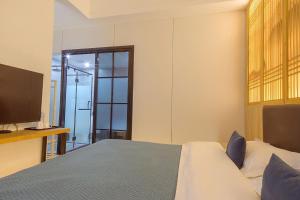 a bedroom with a bed and a flat screen tv at Heinemann Hotel courtyard or terrace king room A108 with a jacuzzi and a local in Baoguosi